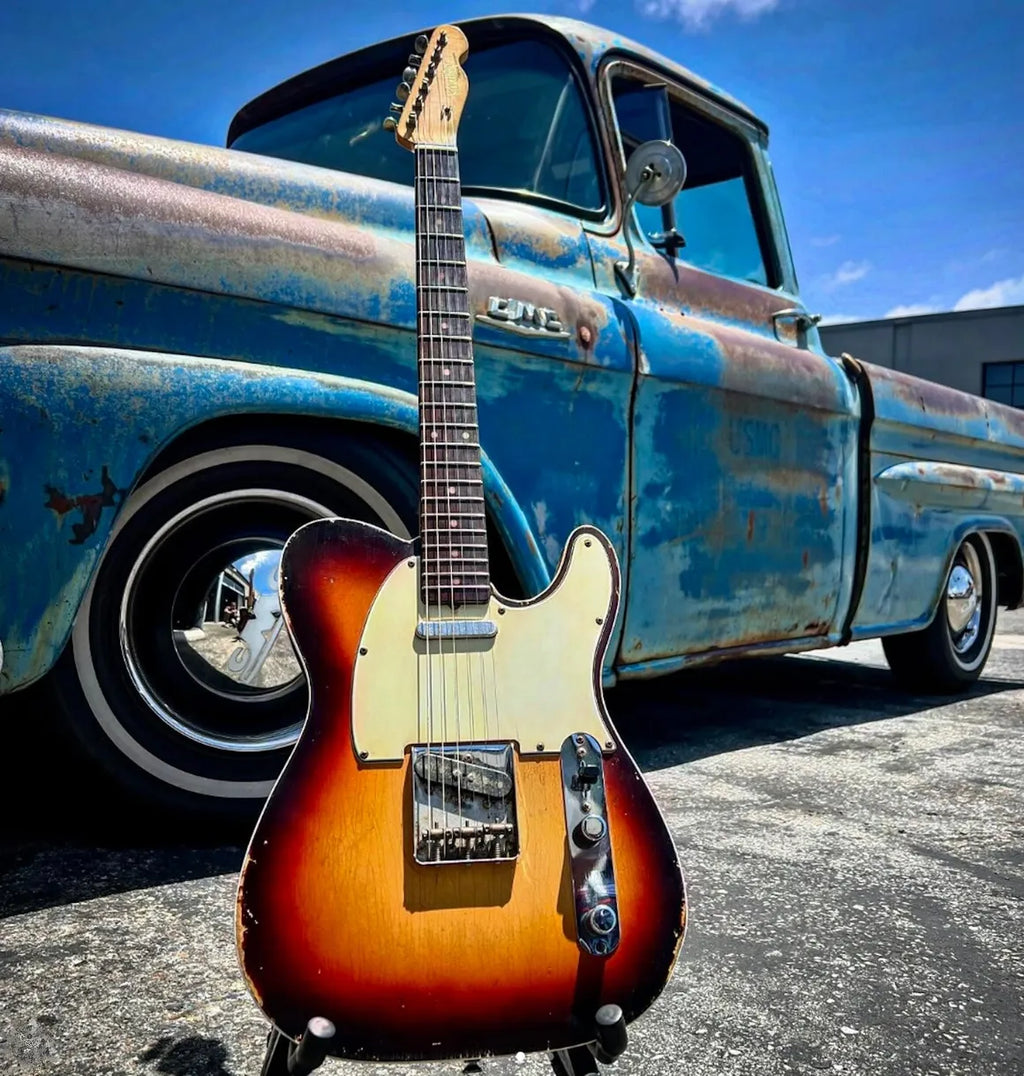 Vintage Revelator sunburst Telecaster with Brickhouse Toneworks pickups leaning against a classic GMC truck